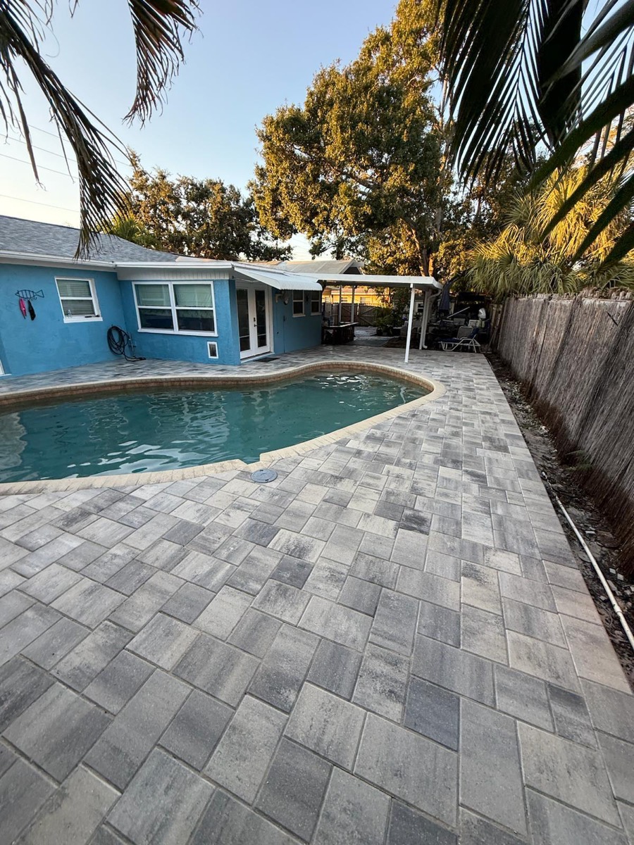 Backyard pool surrounded by charcoal-blend pavers