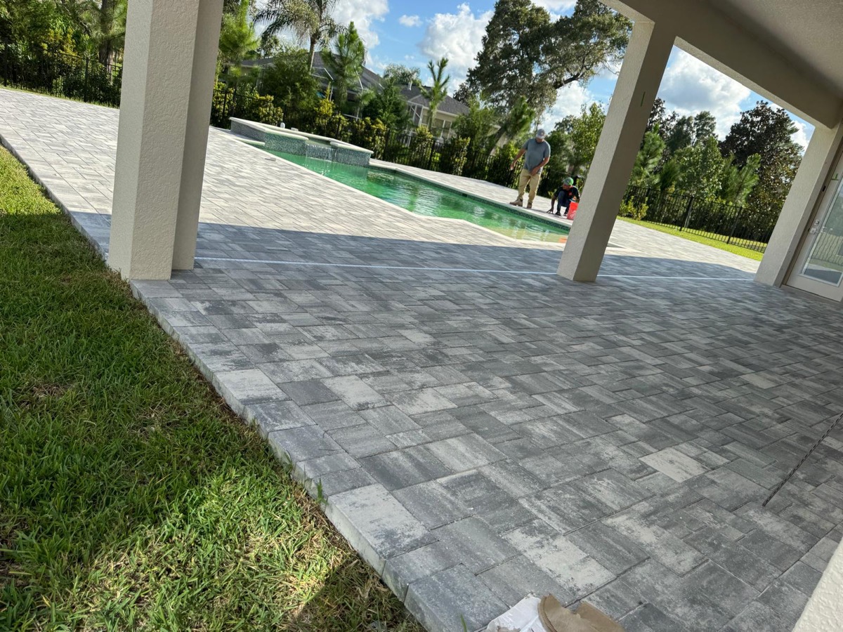 Covered lanai and pool deck in light pavers