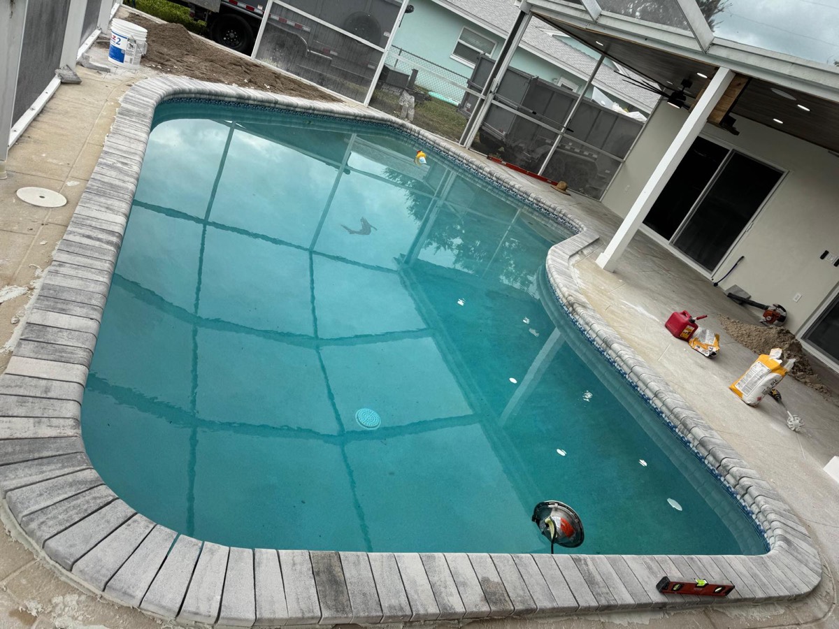 Pool coping being installed around a pool