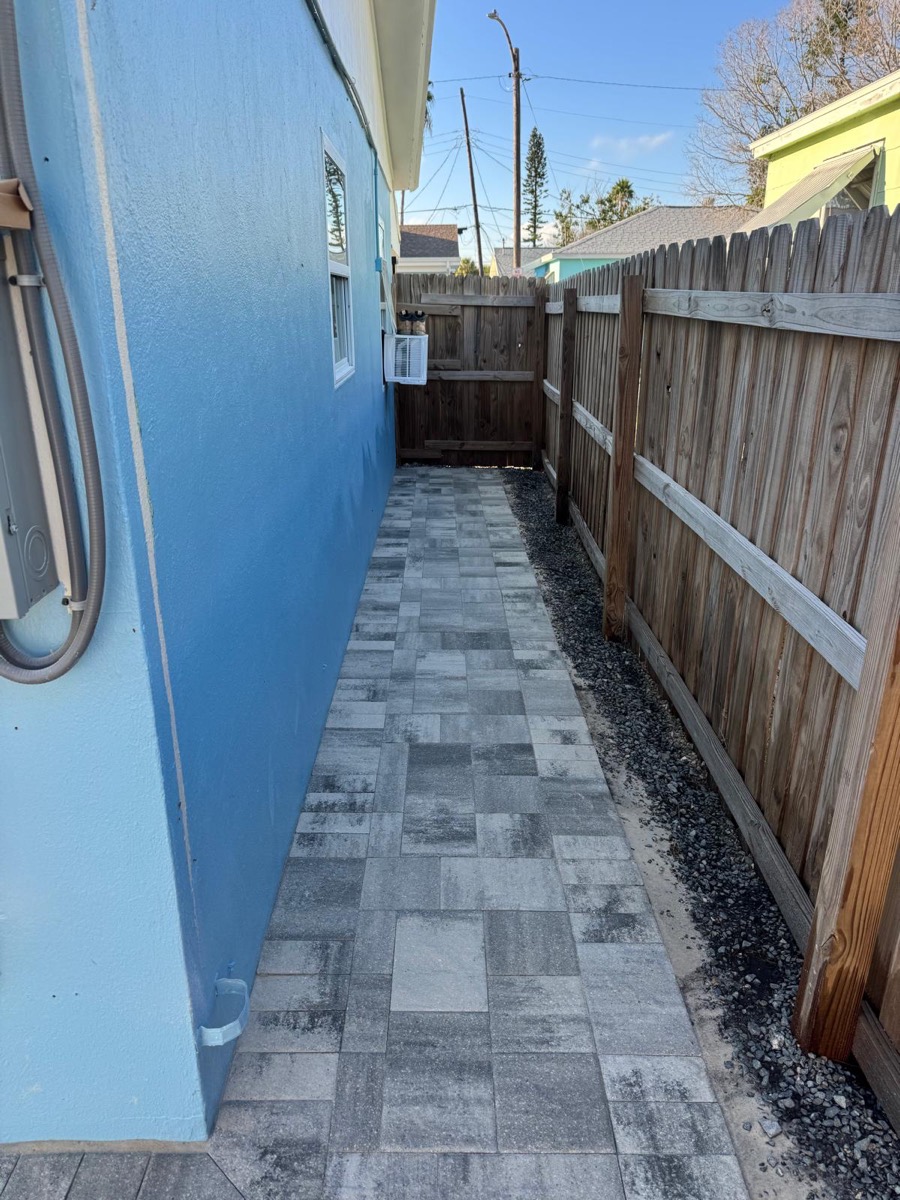 Narrow side-yard walkway in gray pavers