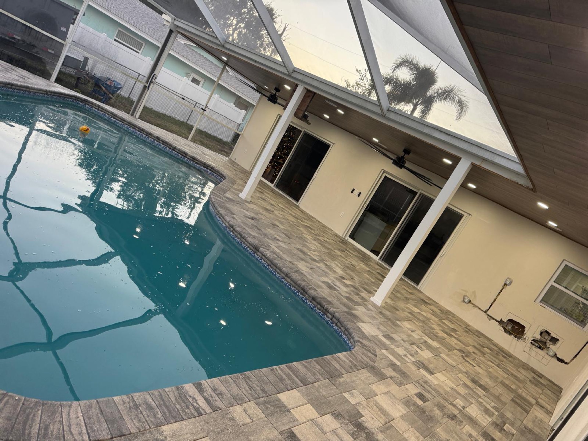 Pool deck in charcoal-blend pavers with a white pavilion, installed by PP Brick Pavers Solutions in Largo, Florida